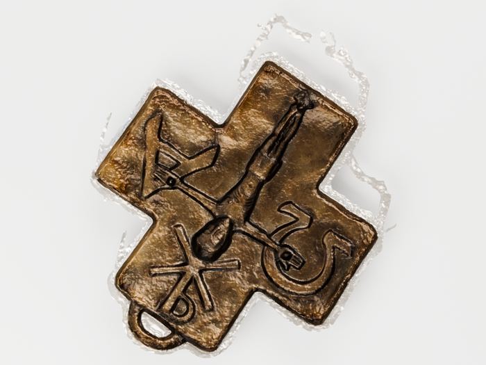 Das rekonstruierte Kreuz von oben: eine Figur mit erhobenen Armen in der Mitte, links und rechts auf den Querarmen je ein Buchstabe, unten ein Monogramm aus gekreuzten Linien, am unteren Rand die Aufhängeöse